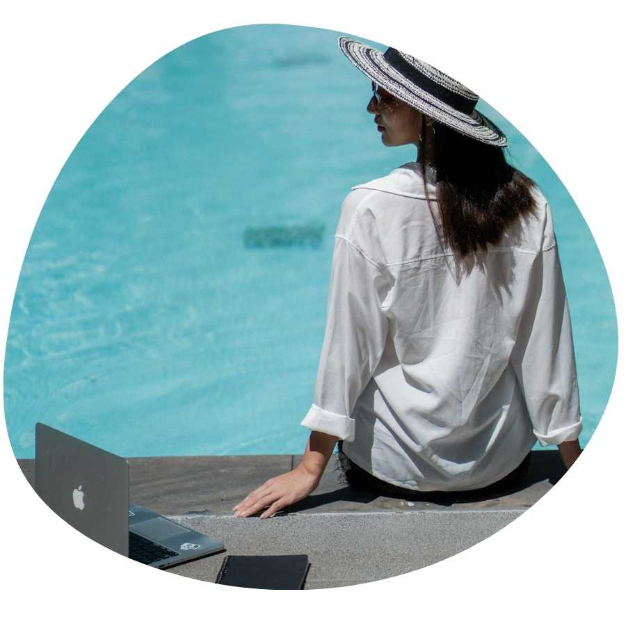 Digital nomad met laptop aan het zwembad